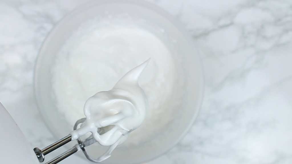 vegan meringue mixture on the end of a whisk attachment
