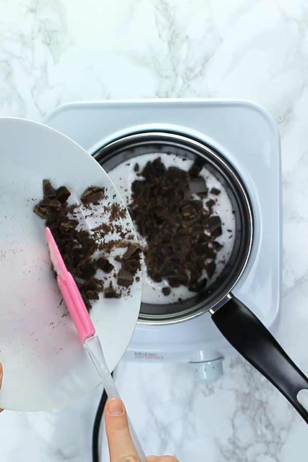 pouring chopped chocolate into pan
