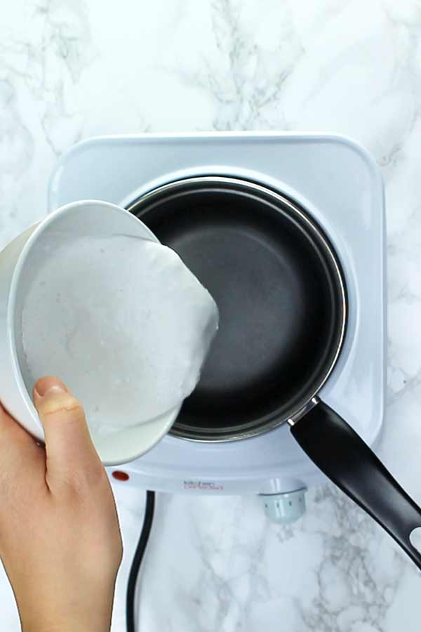 Pouring coconut milk into pan