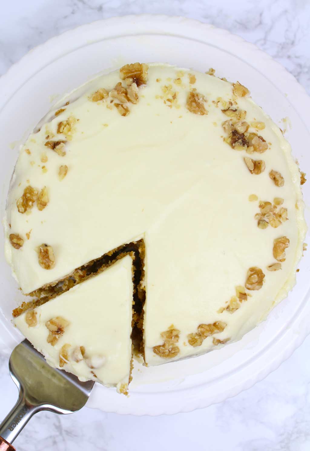 overhead shot of carrot cake with a slice taken out of it 
