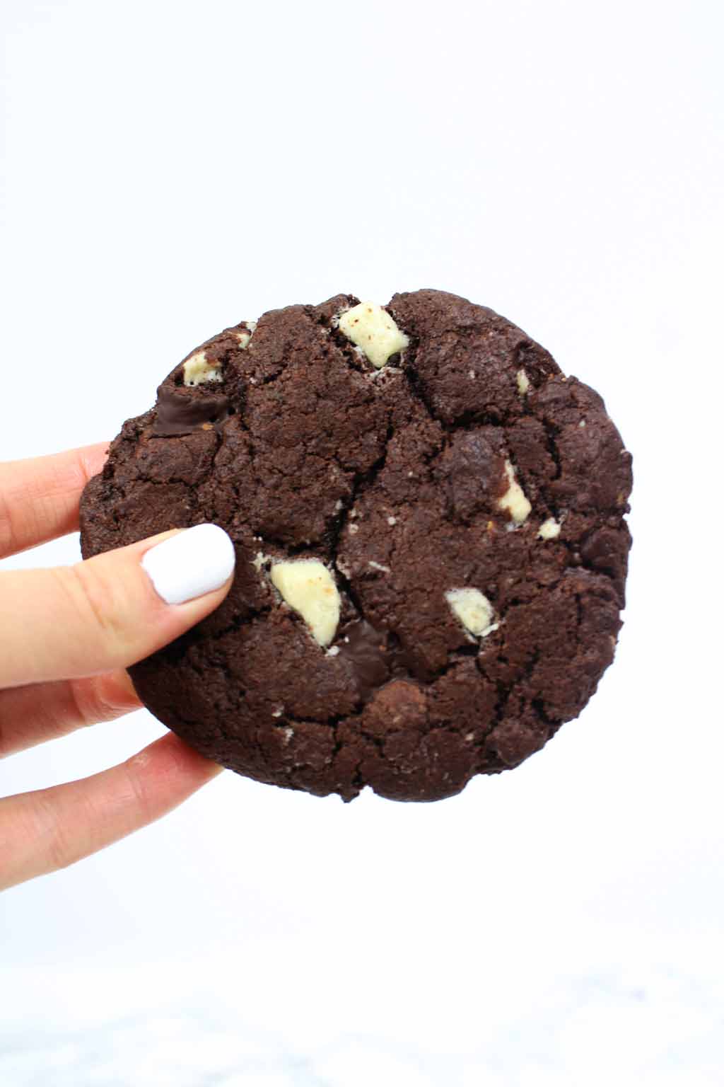 a hand holding a vegan double chocolate cookies