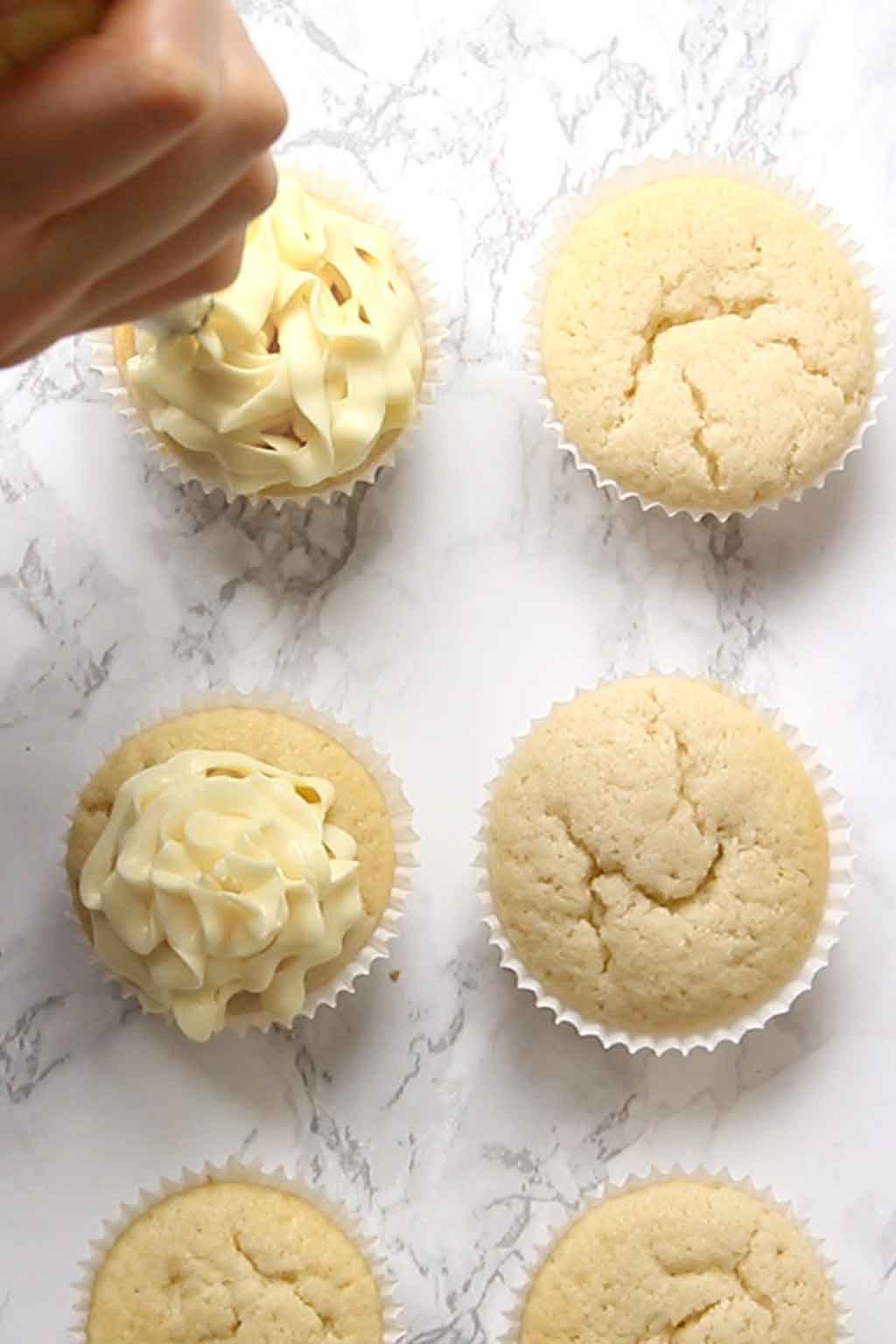 Piping frosting onto cupcake