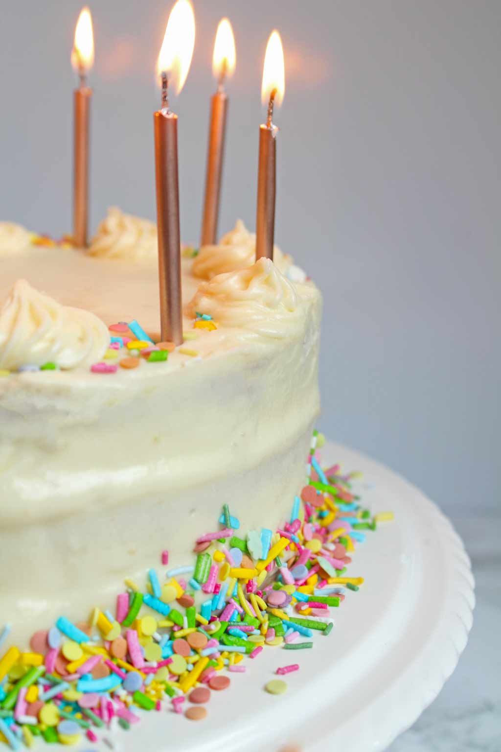 close up of vegan birthday cake with candles on top
