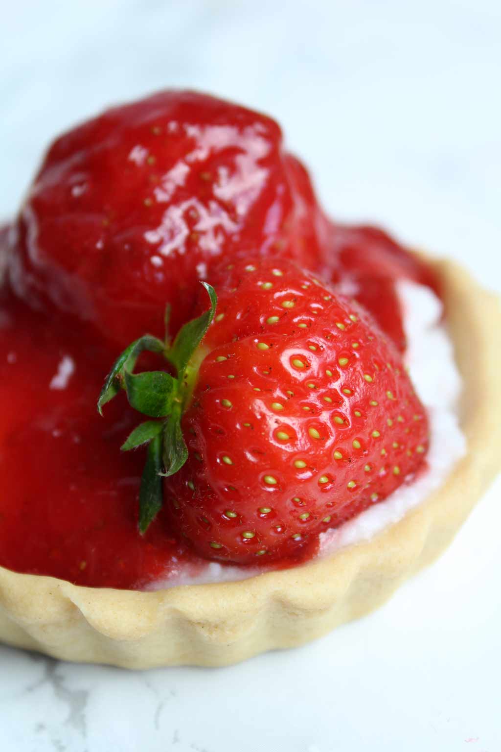 close up of mini fruit tart with a strawberry on top