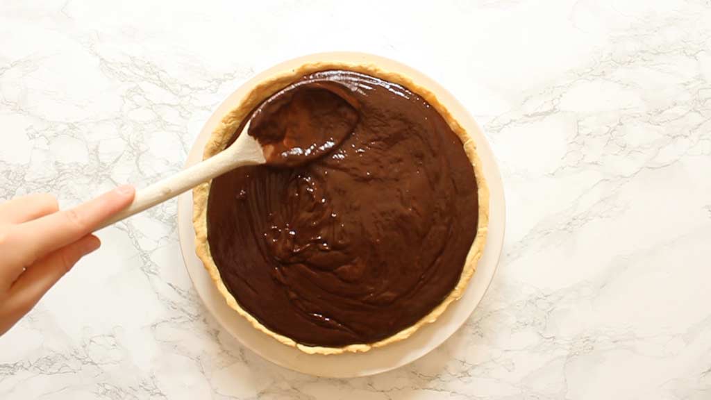 spreading chocolate filling into the crust