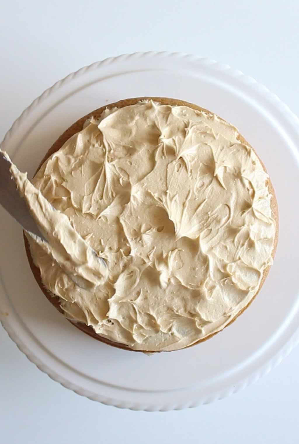 Using a palette knife to create texture on the cake frosting