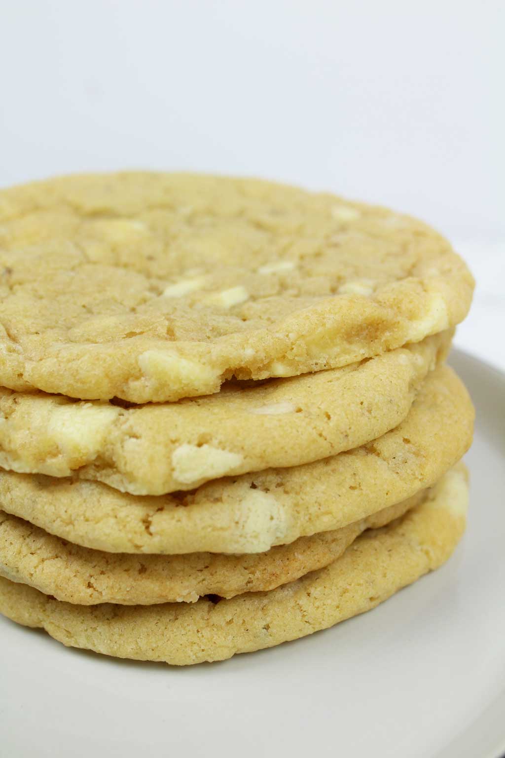 a stack of 5 white chocolate cookies on a plate