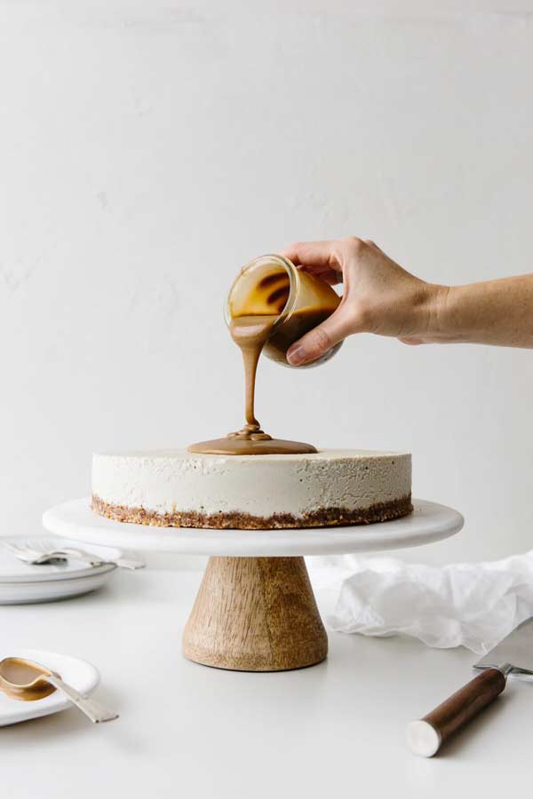 pouring caramel over cheesecake