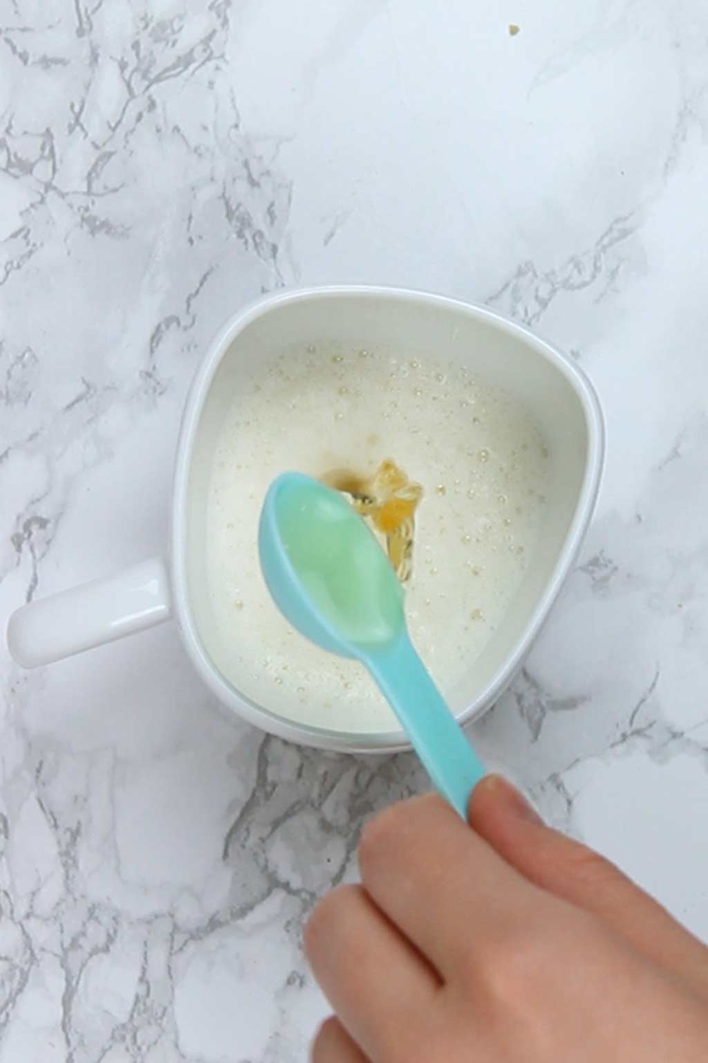 mixing vinegar and soy milk together in a mug
