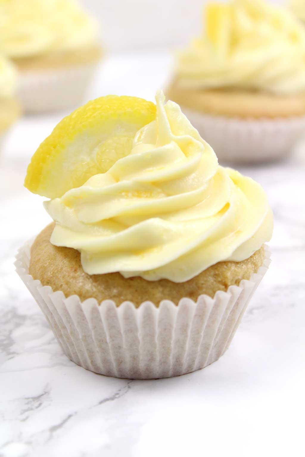 close up of a lemon cupcake with frosting on top