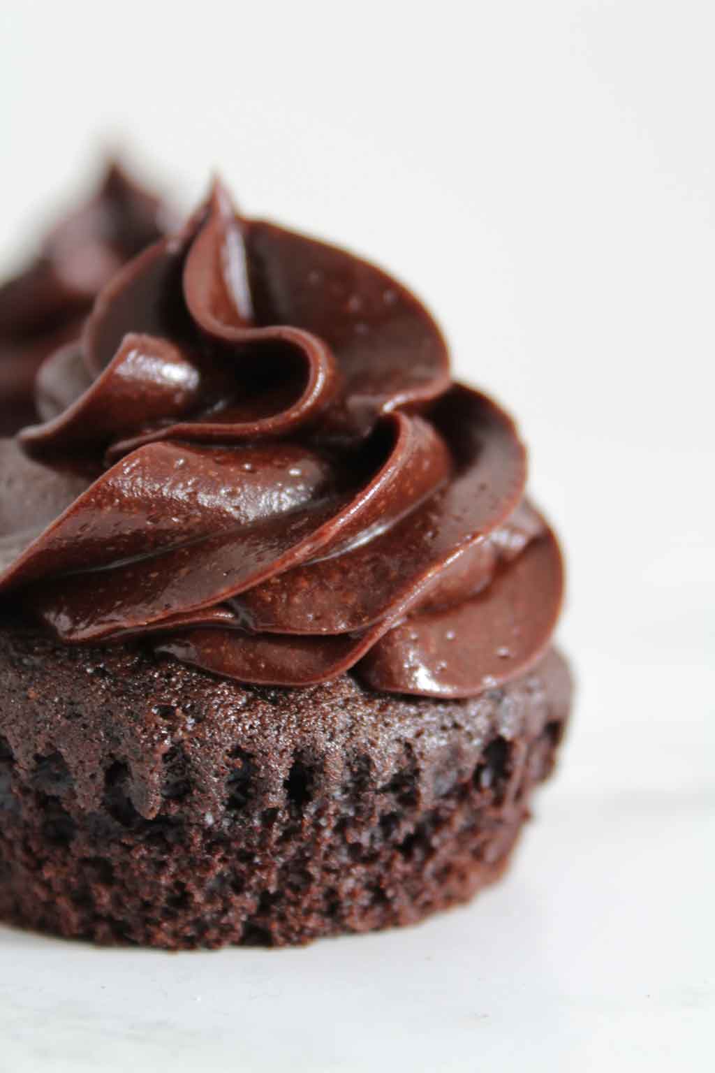 a vegan chocolate cupcake with chocolate frosting on top