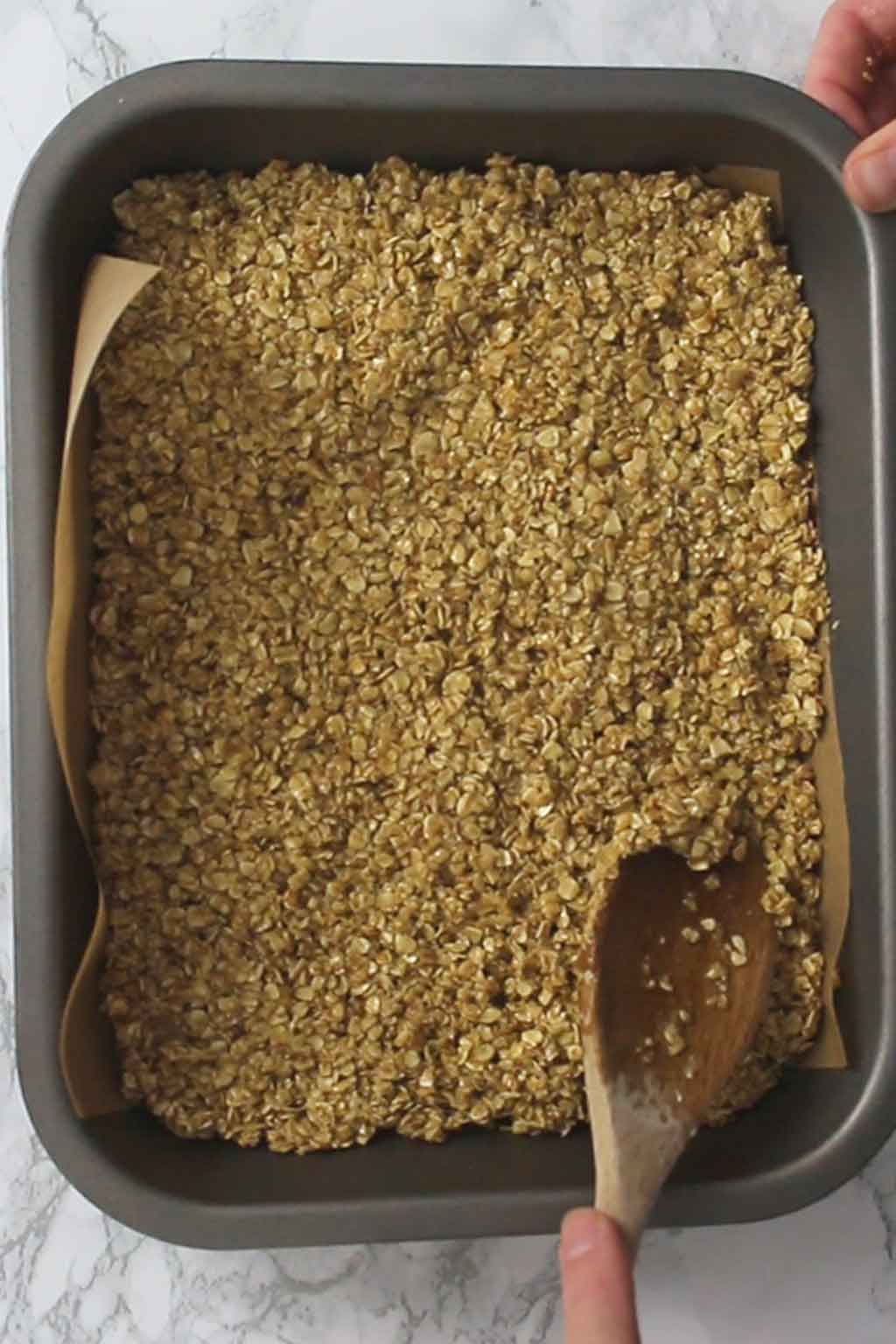 Packing flapjack mix into the tin