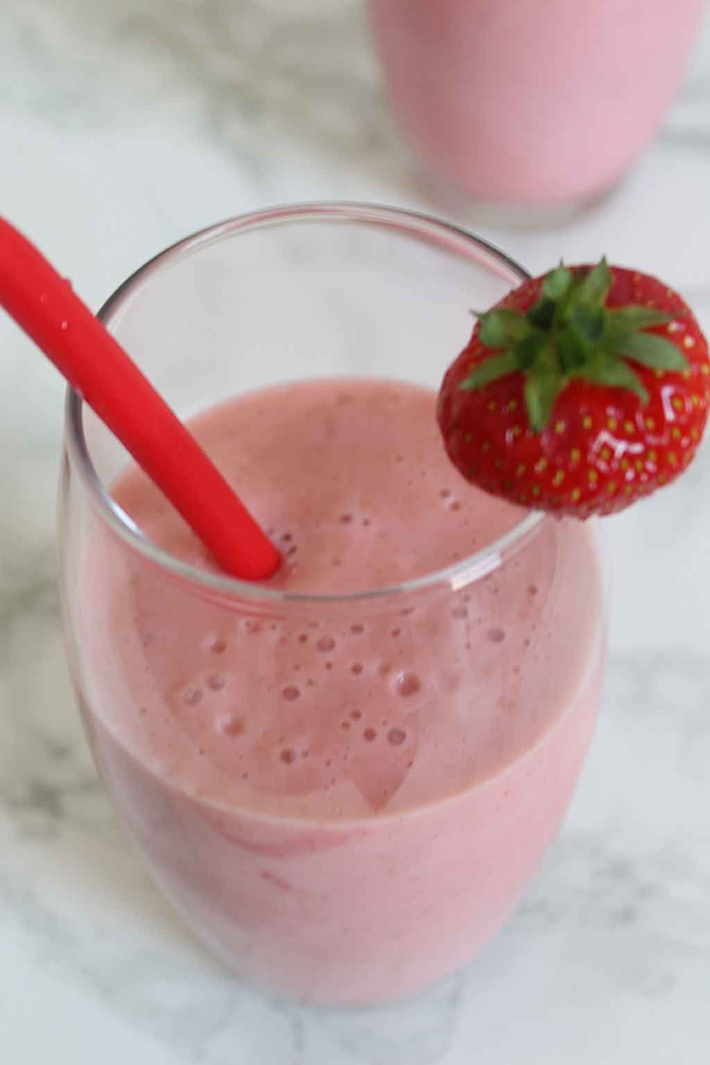 Strawberry Shake in a glass with a red straw in it