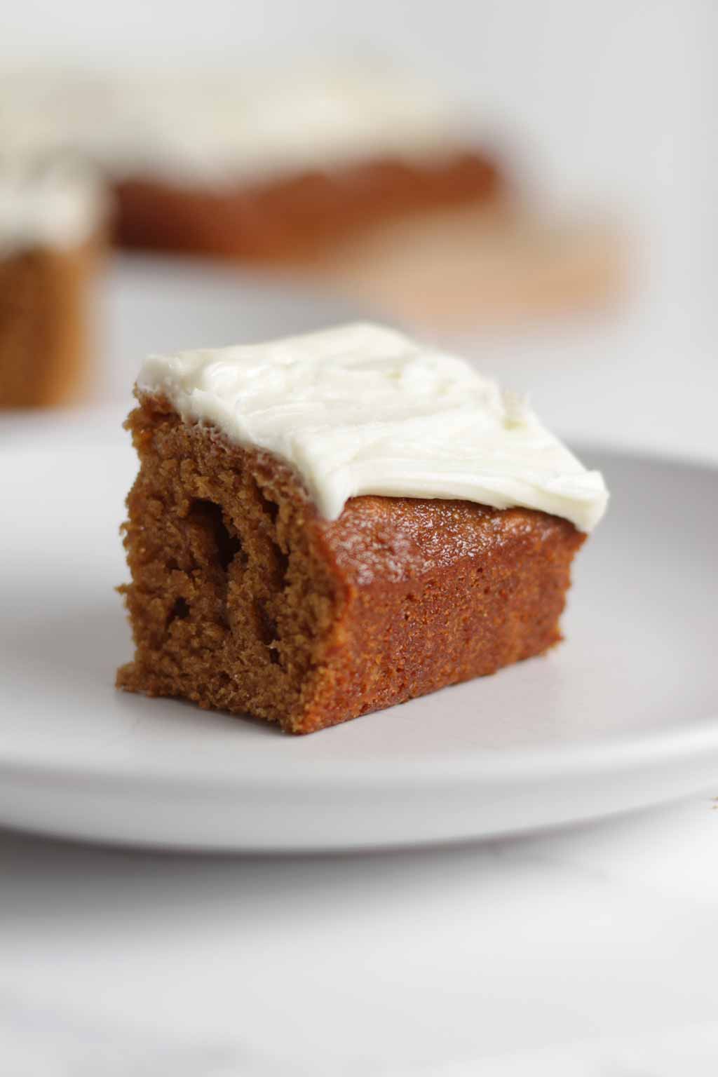 slice of vegan Ginger Cake on a plate with icing on top