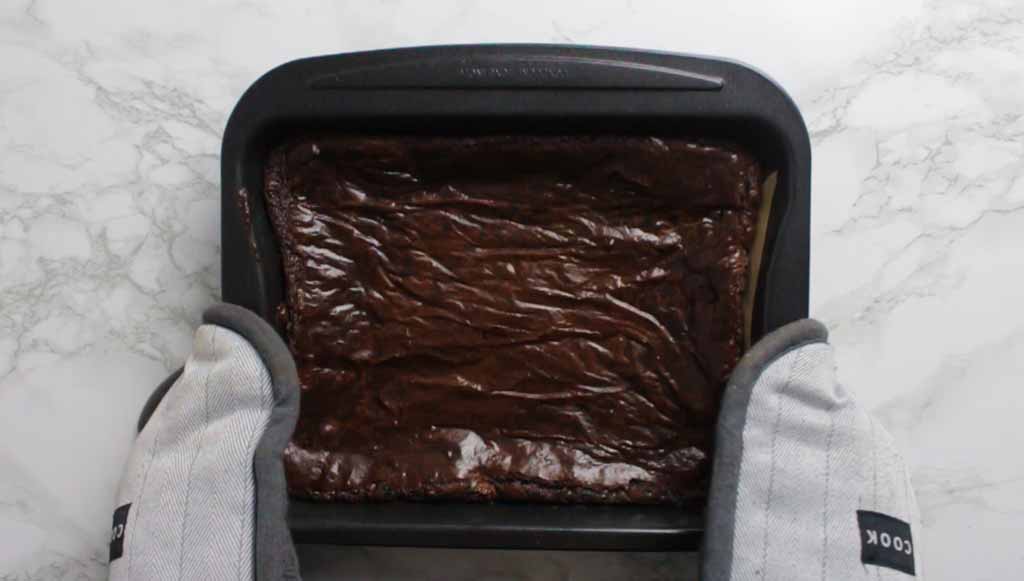 Gloved Hands Holding The Tray Of Baked Brownies