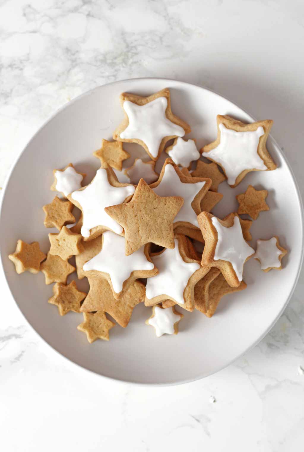 Overhead Shot Of Star Shaped Cinnamon Cookies On A White Plate