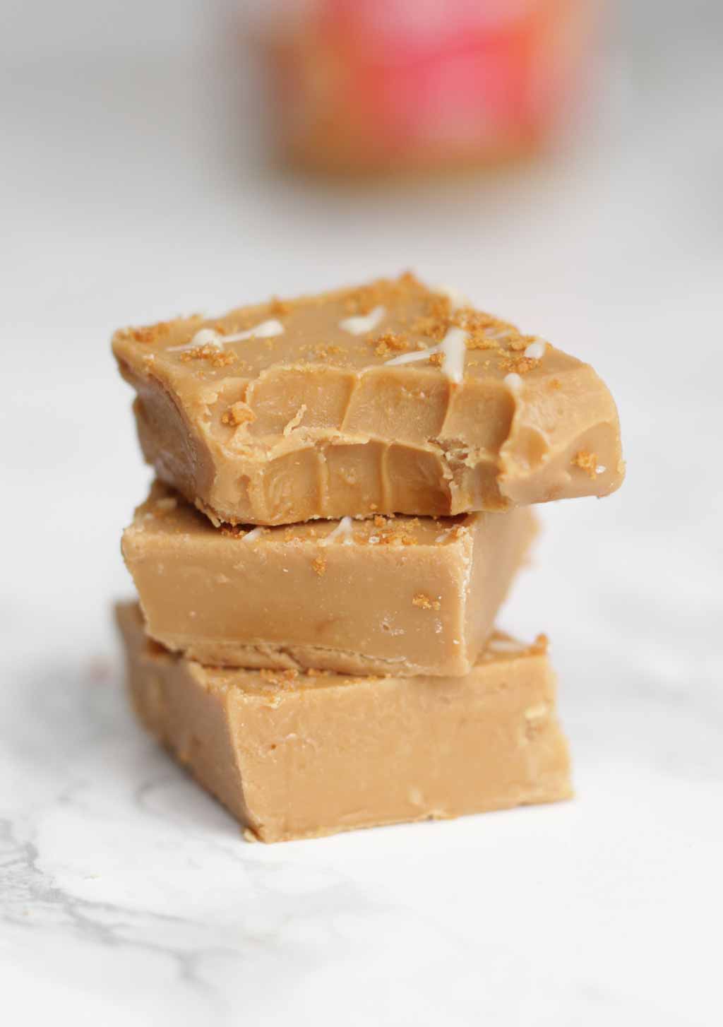 3 Pieces Of Fudge Stacked On Top Of One Another. The Top Piece Has A Bite Taken Out Of It