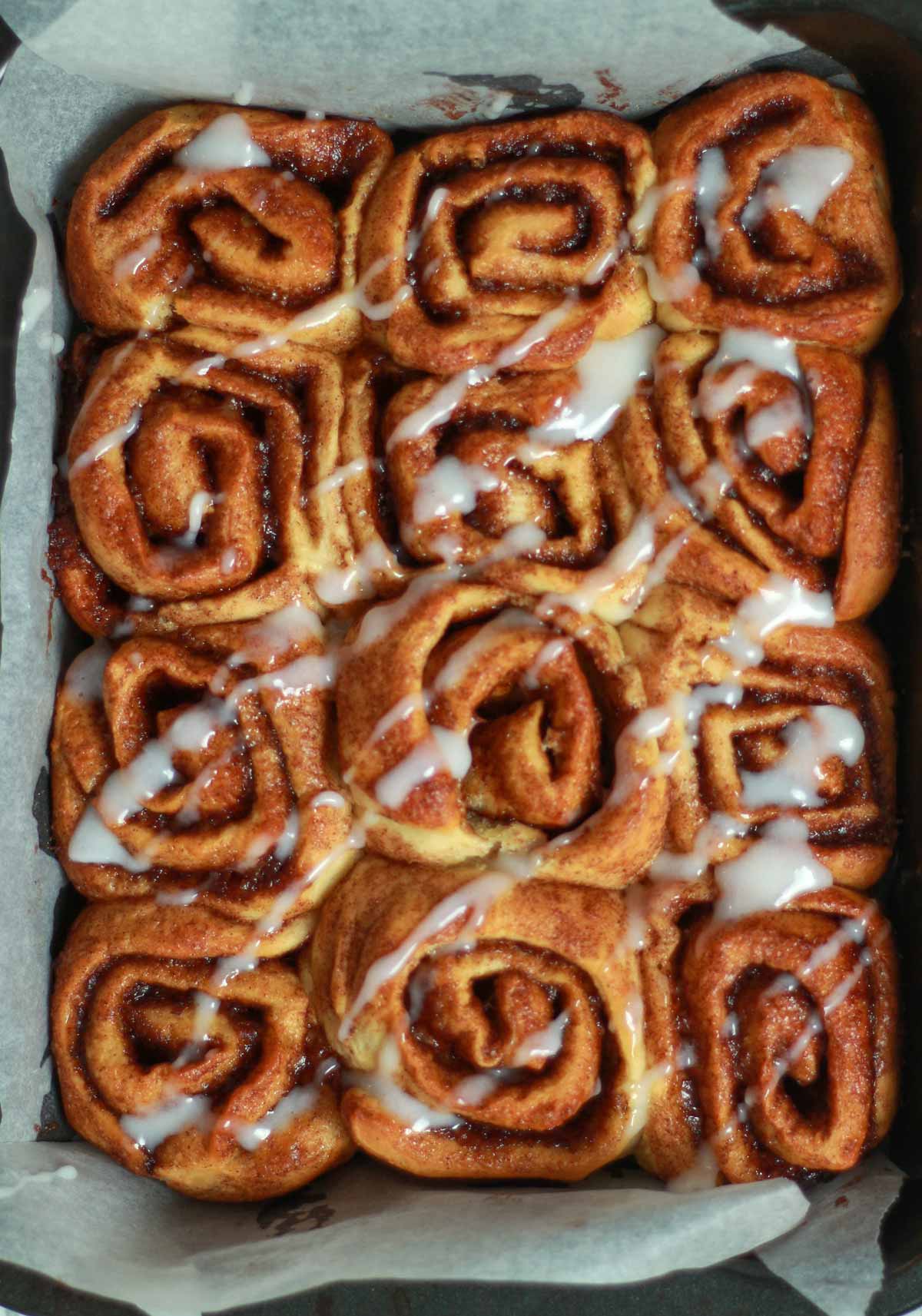 Cream Cheese Icing Drizzled On Top Of The Warm Cinnamon Rolls