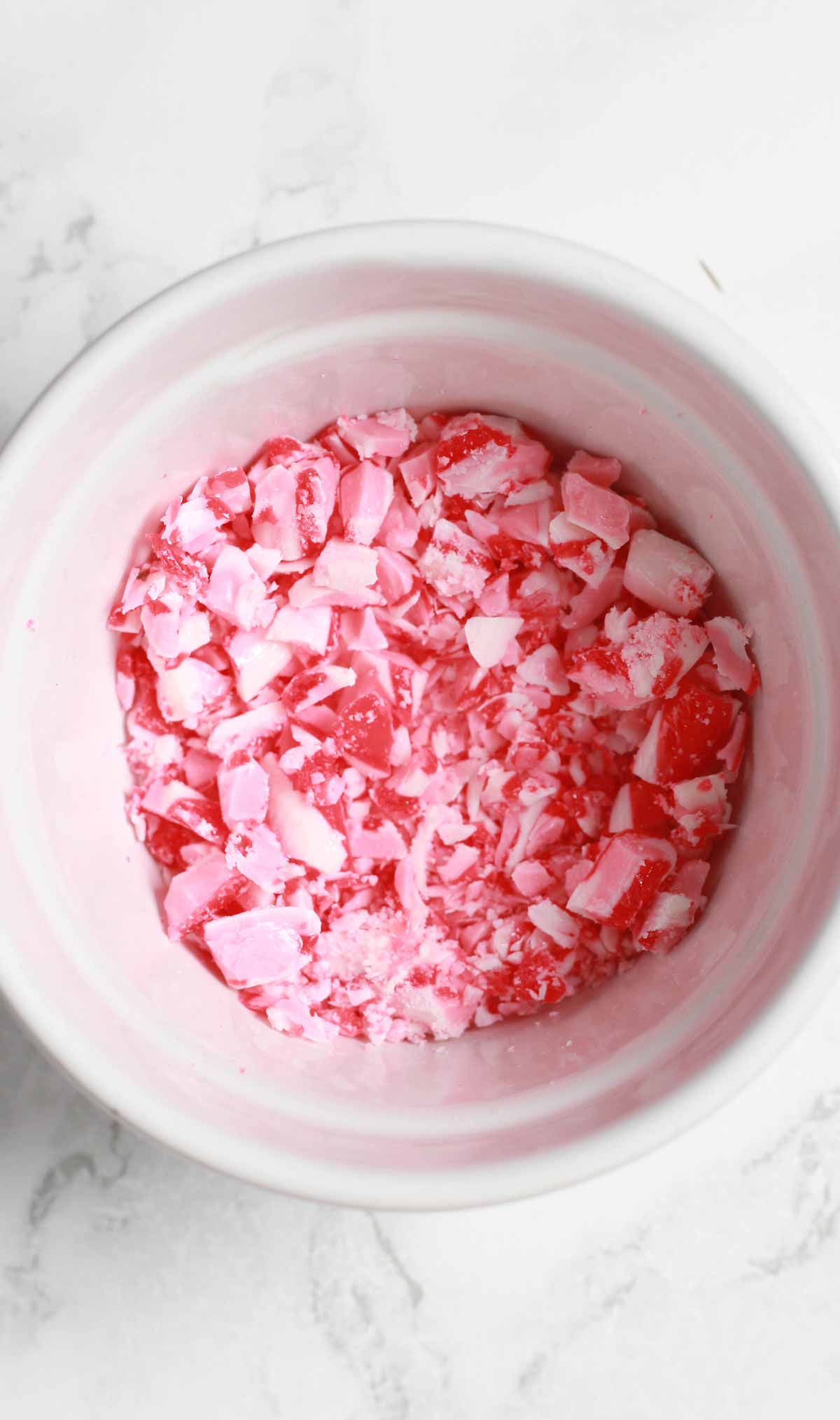 Red And White Candy Cane Pieces Crushed Up In A White Bowl