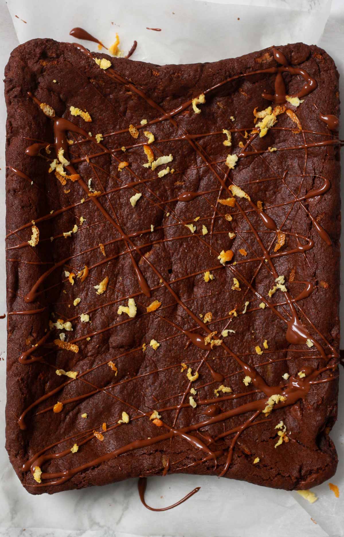 Slab Of Baked Cookie With Chocolate Drizzle And Orange Zest On Top
