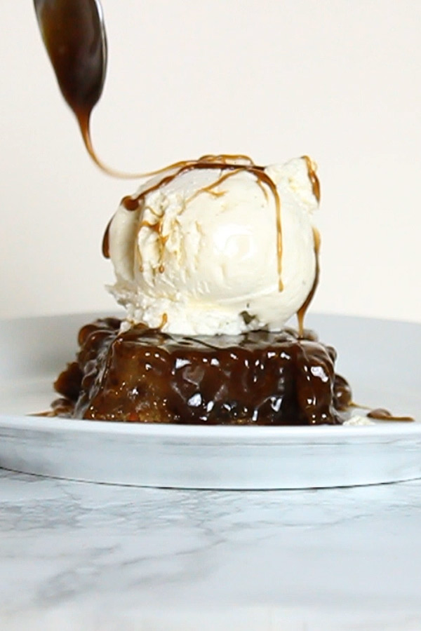 a slice of sticky toffee pudding with vanilla ice cream on top