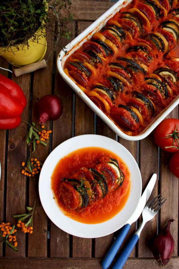 Bowl of ratatouille beside tray of ratatouille