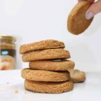 Hand lifting a peanut butter cookie from a stack