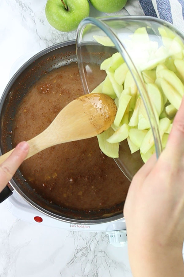 Pouring apples into filling mixture on pan