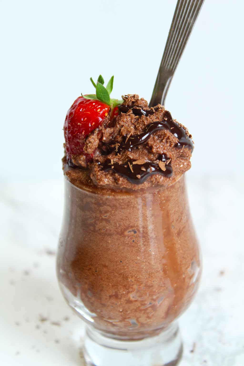 low carb chocolate mousse in a small jar, with chocolate sauce and strawberry on top