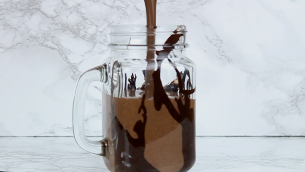 pouring cookies and cream milkshake into glass