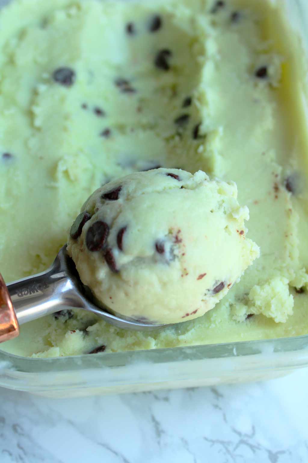 Creamy vegan mint choc chip ice cream in a container