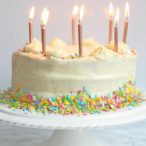 vegan birthday cake on a stand with candles