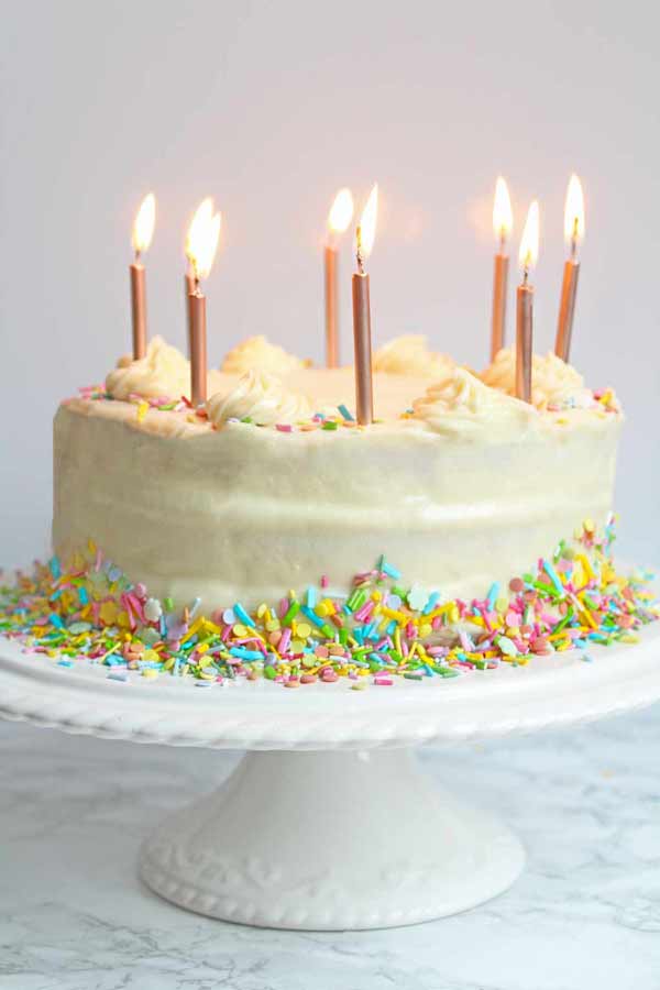 vegan birthday cake on a stand with candles