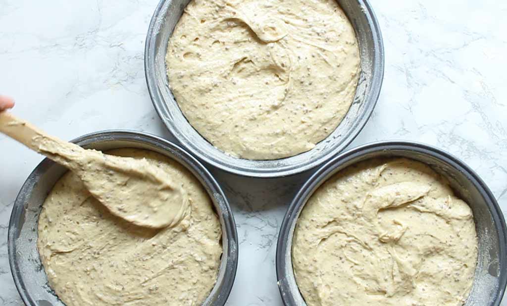 cake batter separated into 3 cake tins