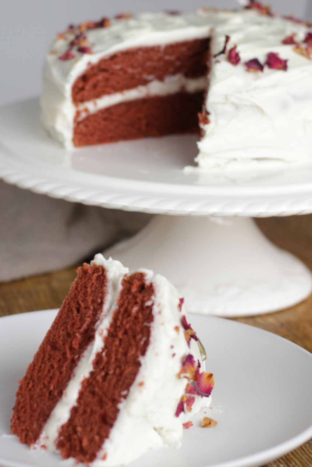 Slice Of Cake On A Plate In Front Of The Rest Of The Cake