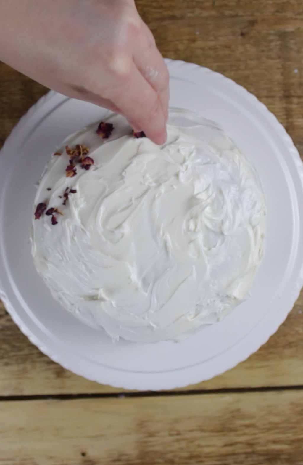 Sprinkling Rose Petals On Top Of The Cake