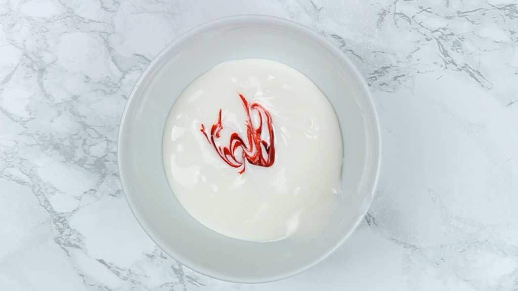 a bowl of icing with red food colouring added