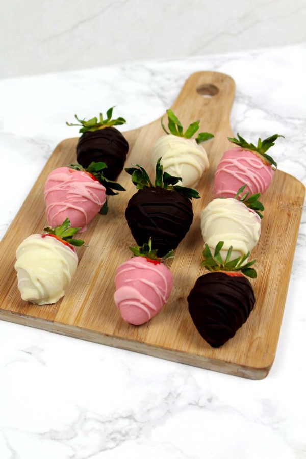 vegan chocolate coated strawberries on a wooden board