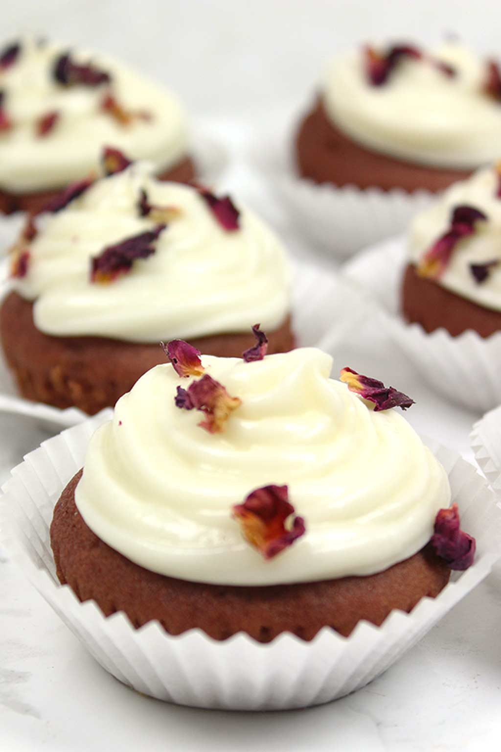 close up of one red velvet cupcake with others in the background