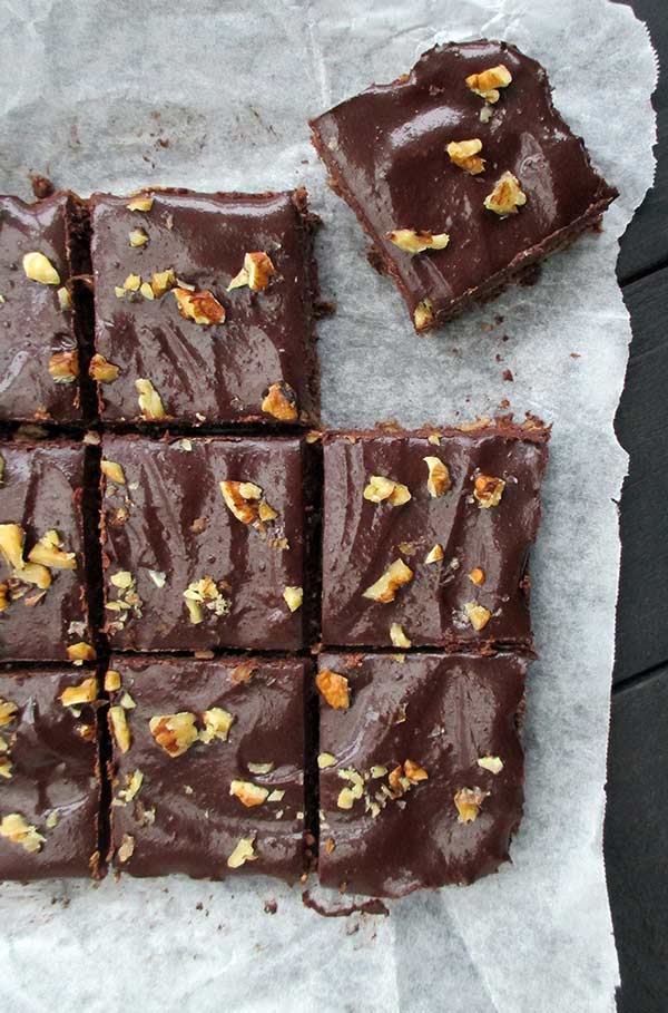 Squares of walnut chocolate slice on parchment paper