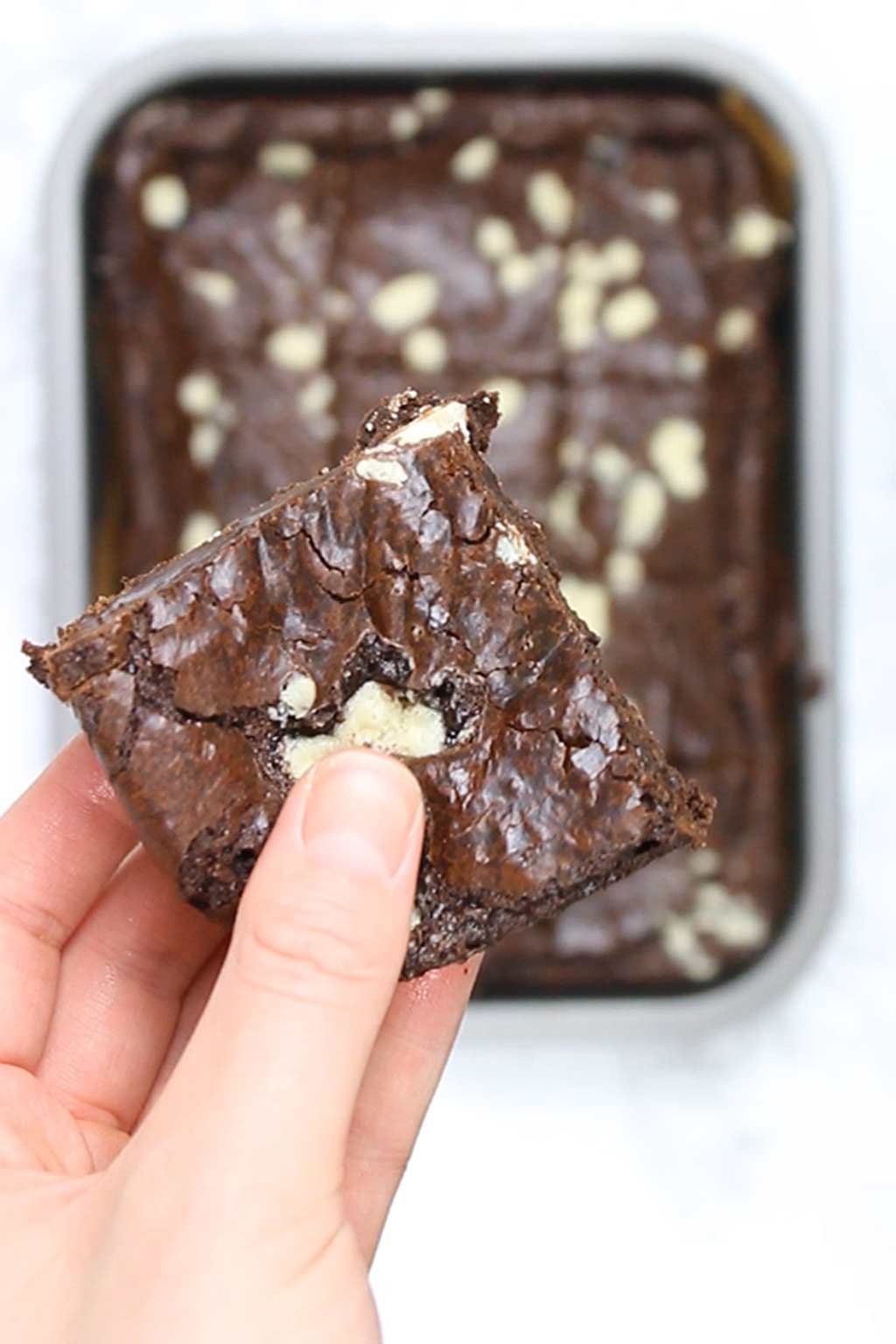 hand holding a square of brownies