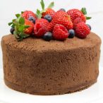 whole chocolate cake with frosting all over and berries on top