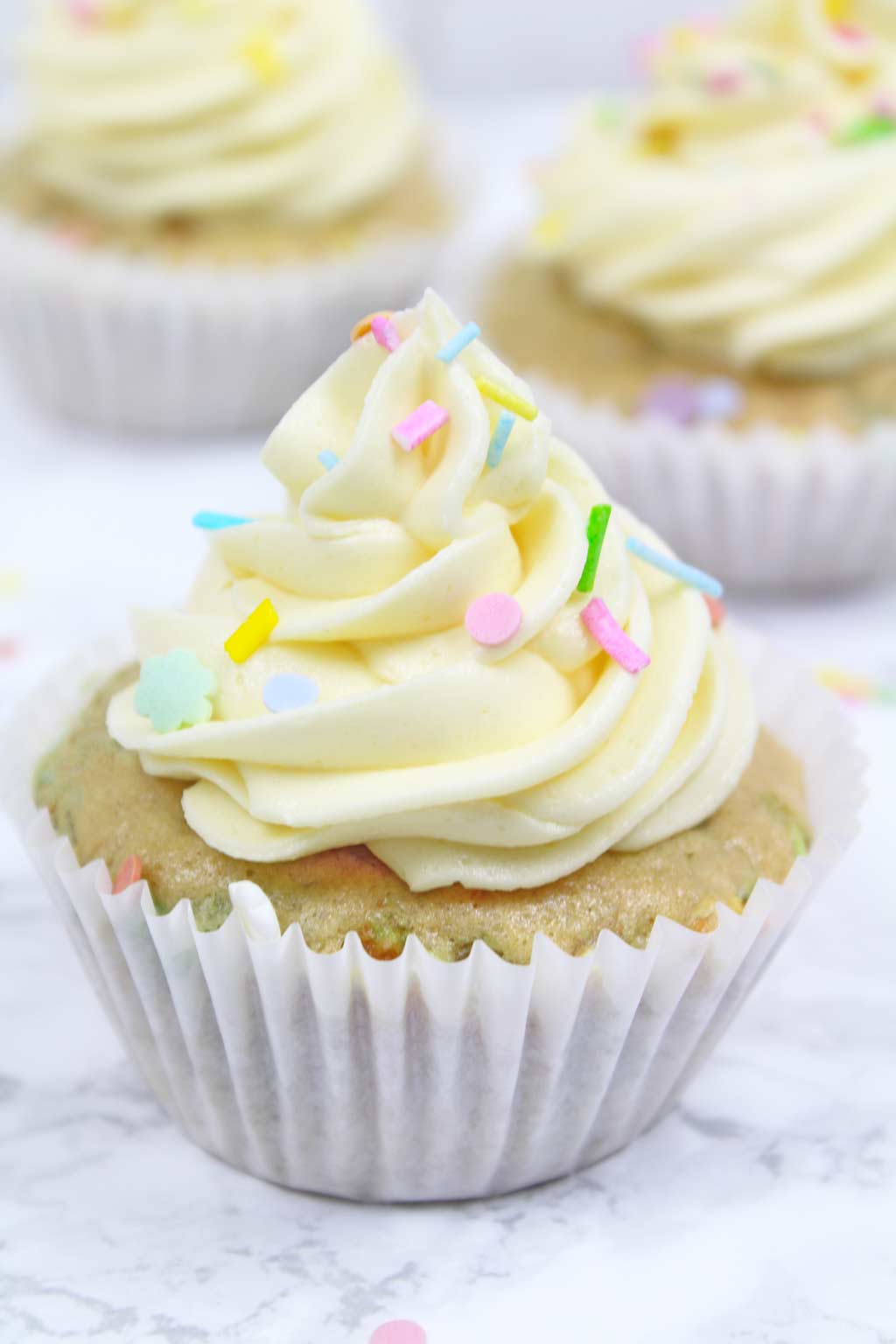 vegan funfetti cupcake with 2 more in the background