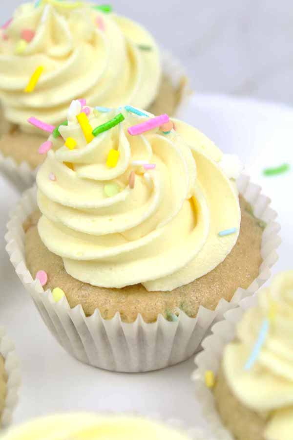 vanilla cupcake with frosting and colourful sprinkles on top