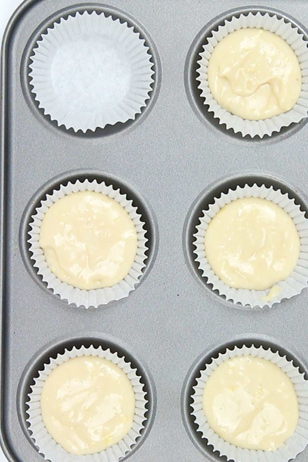 cake batter in cupcake cases on a tray