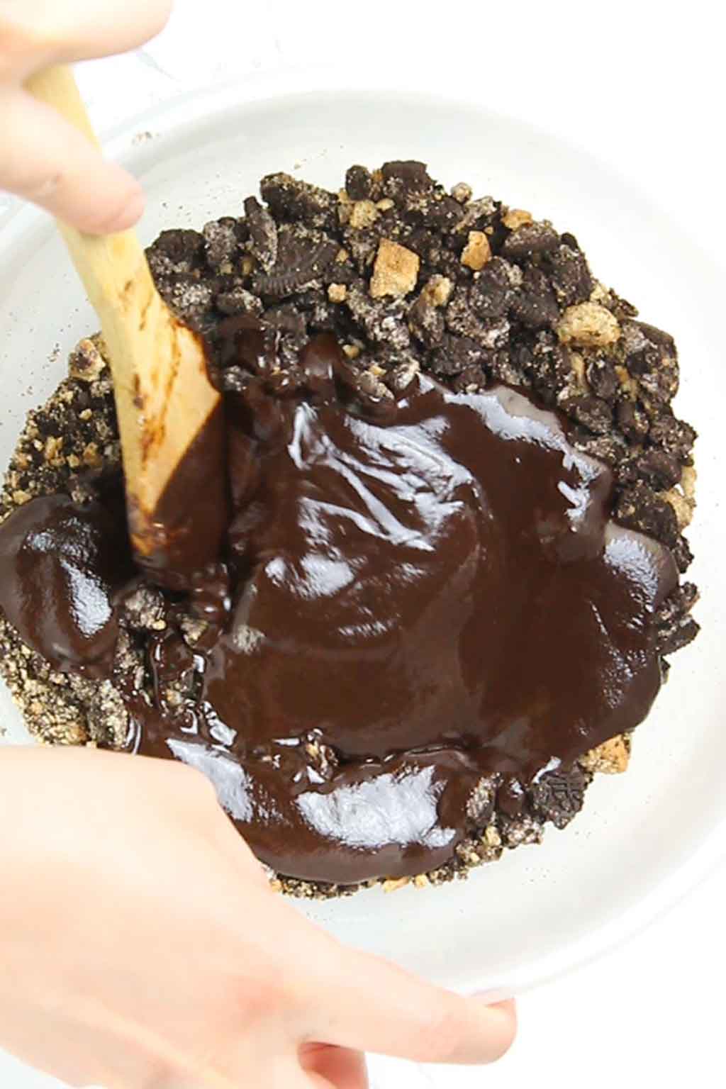 Mixing the chocolate into the cookie crumbs