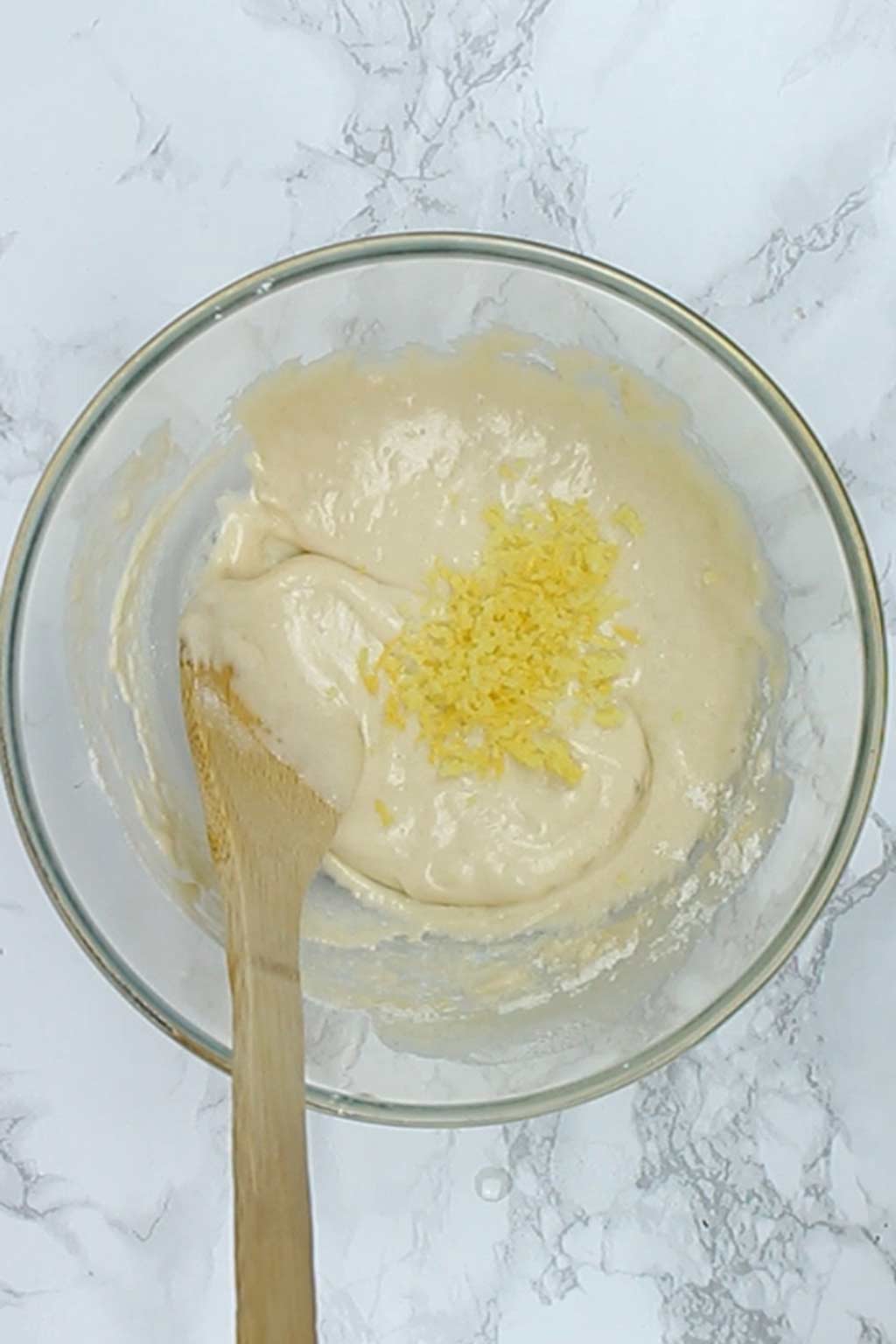 lemon zest sitting on top of the cake batter in the bowl