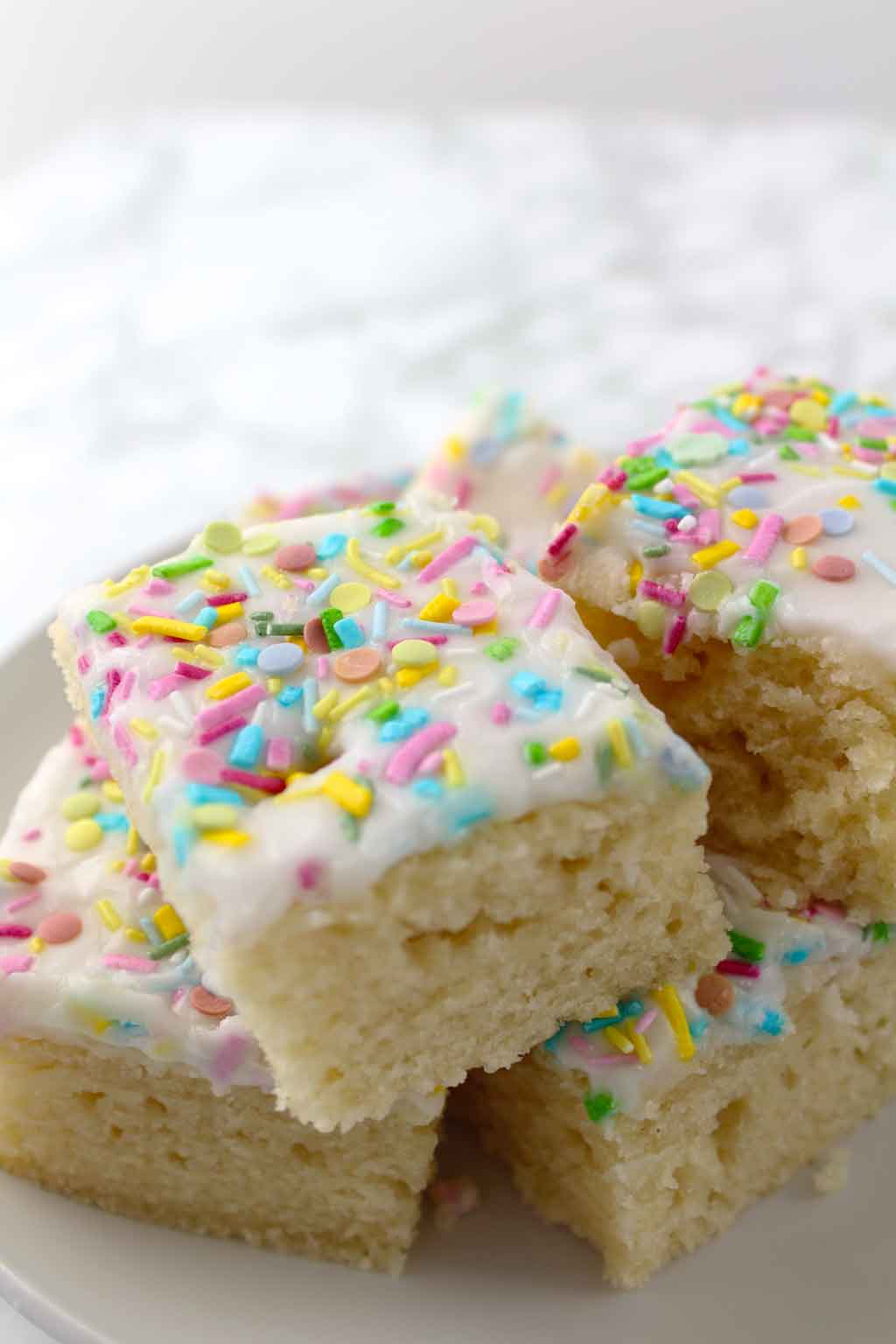 squares of vanilla cake stacked on top of one another