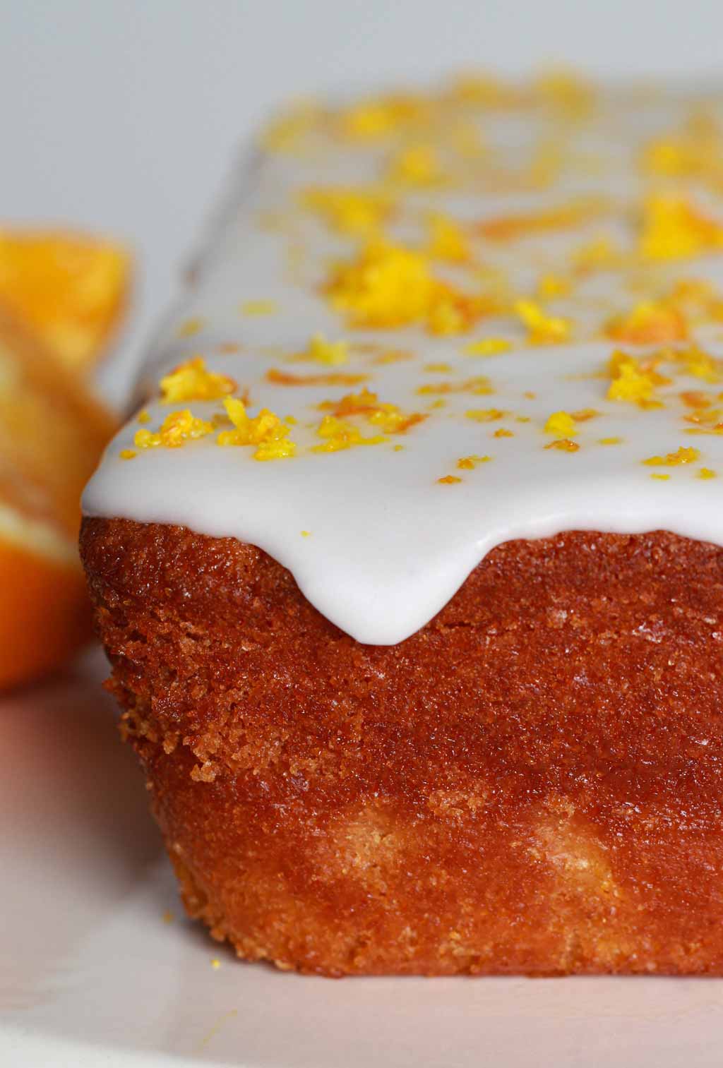 Close Up Of Orange Cake With Icing Dripping Down The Side