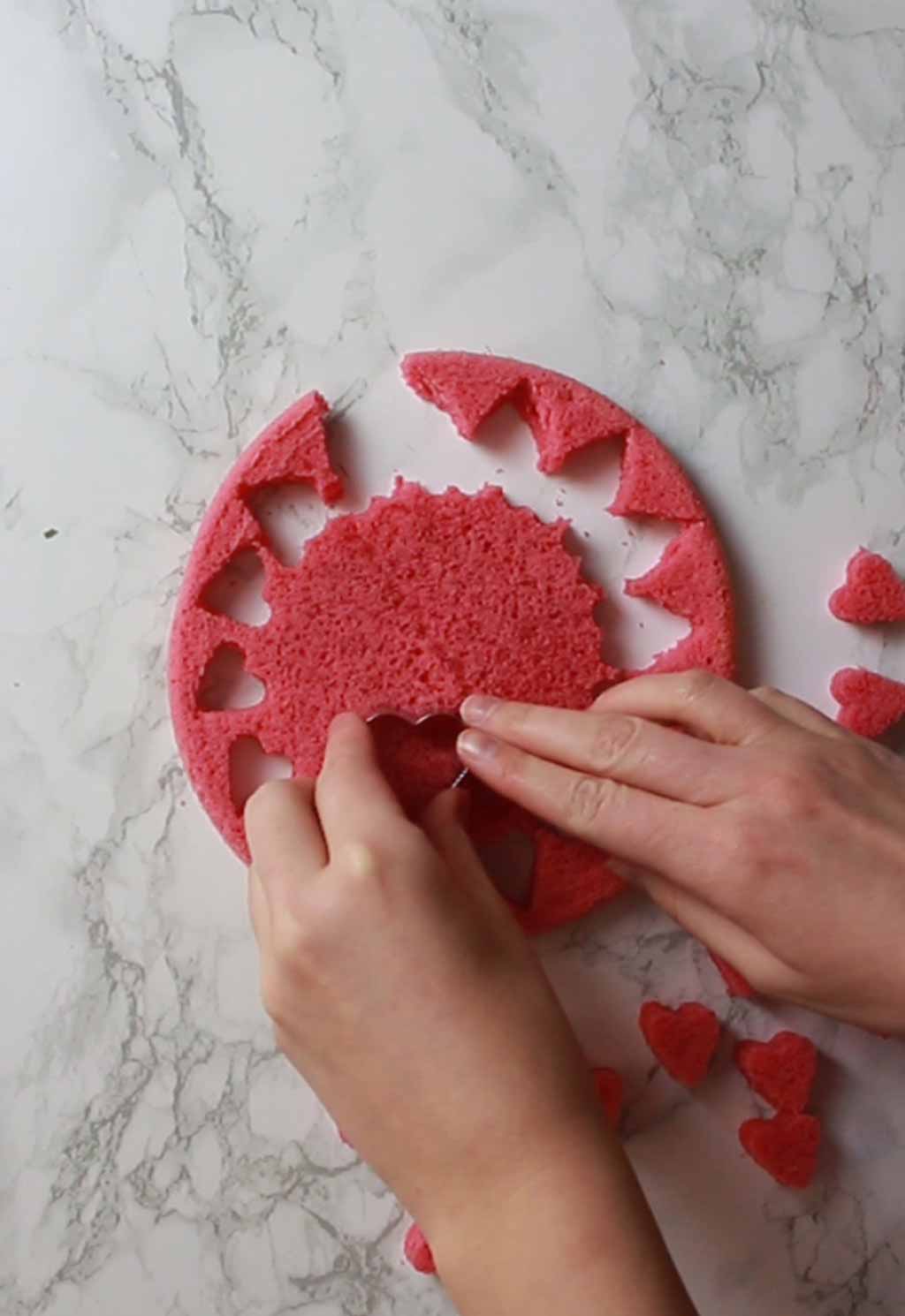 Cutting Heart Shapes Out Of Pink Cake